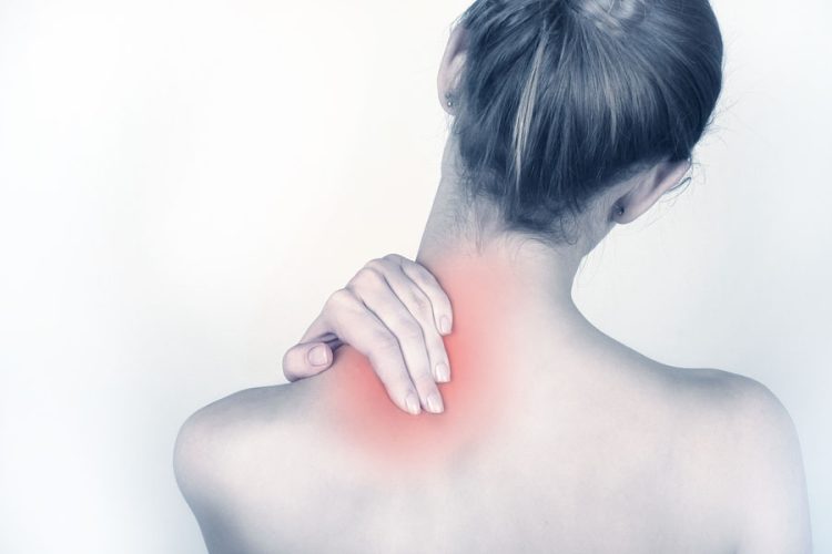 Achterkant van een dame met rode plek die pijn in nek en schouders symboliseert.